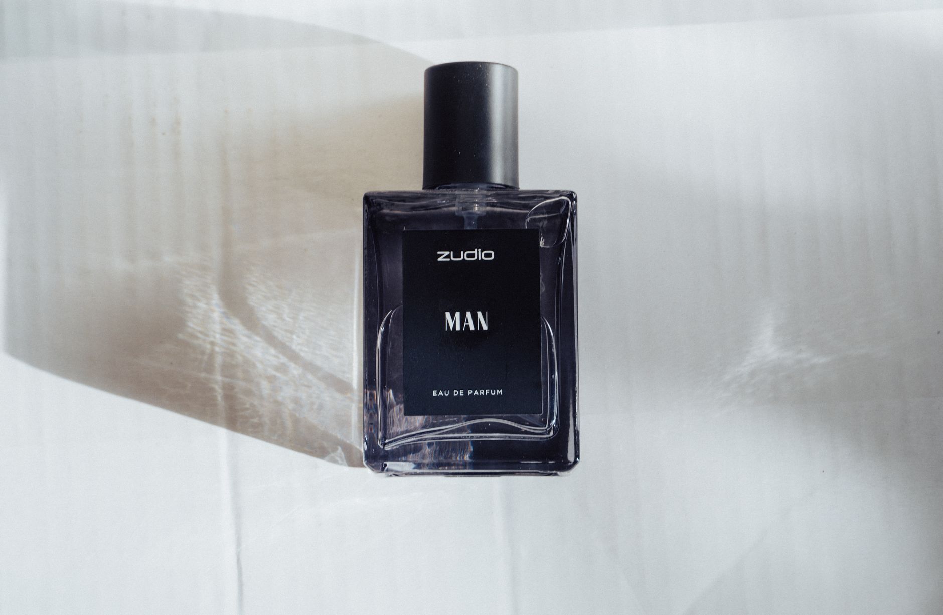 Elegant minimalist perfume bottle with natural shadow play, perfect for luxury product displays.