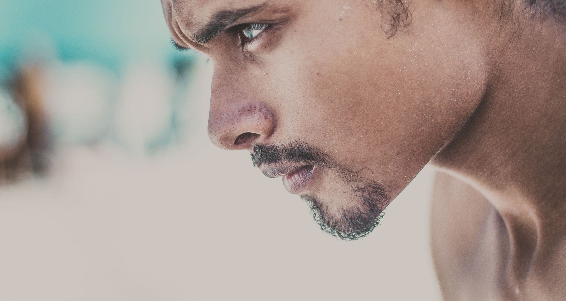 A close-up side view of a young man with a serious and focused expression.