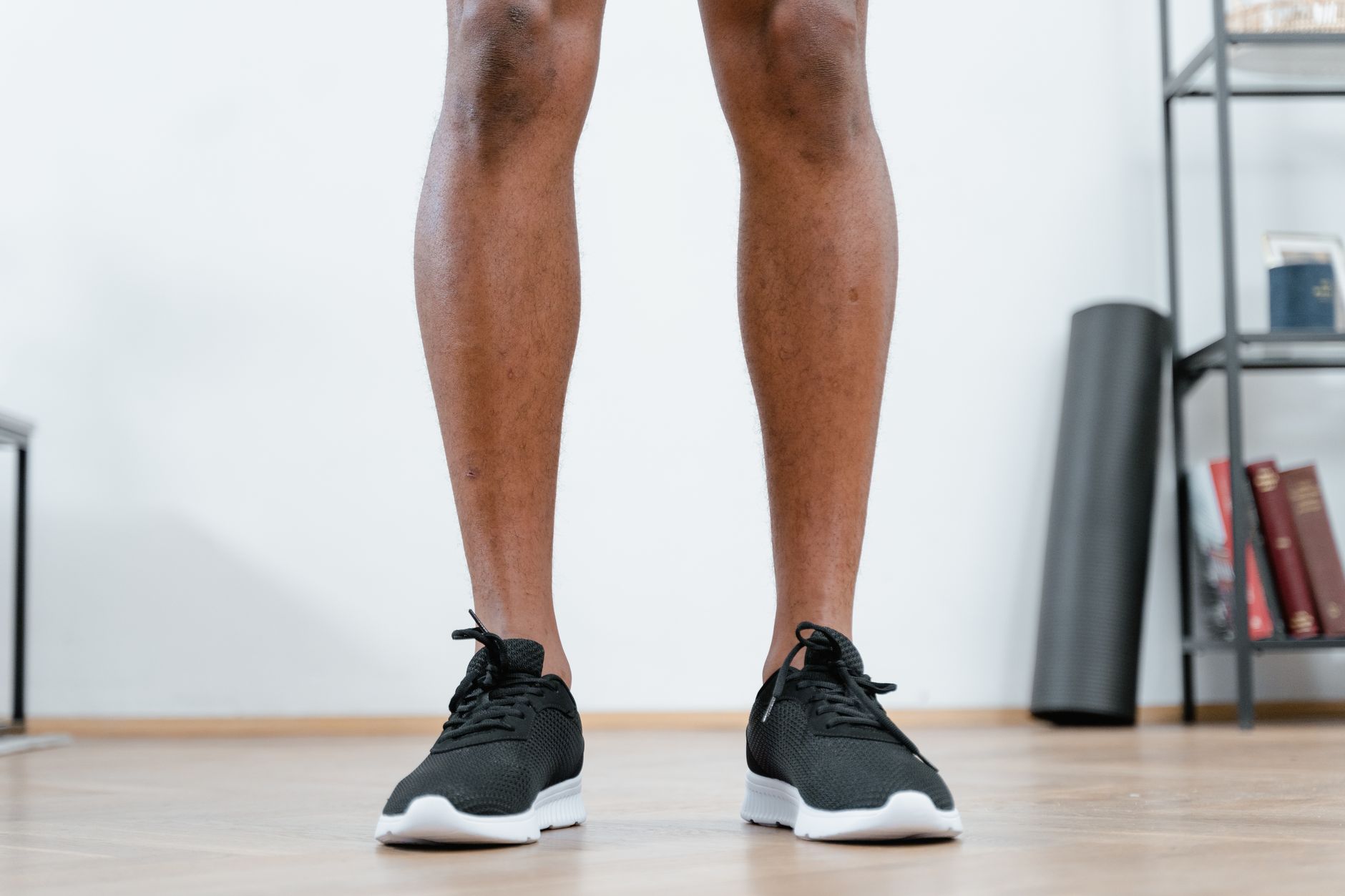 Detailed shot of black running shoes on a wooden floor, perfect for fitness and workout themes.