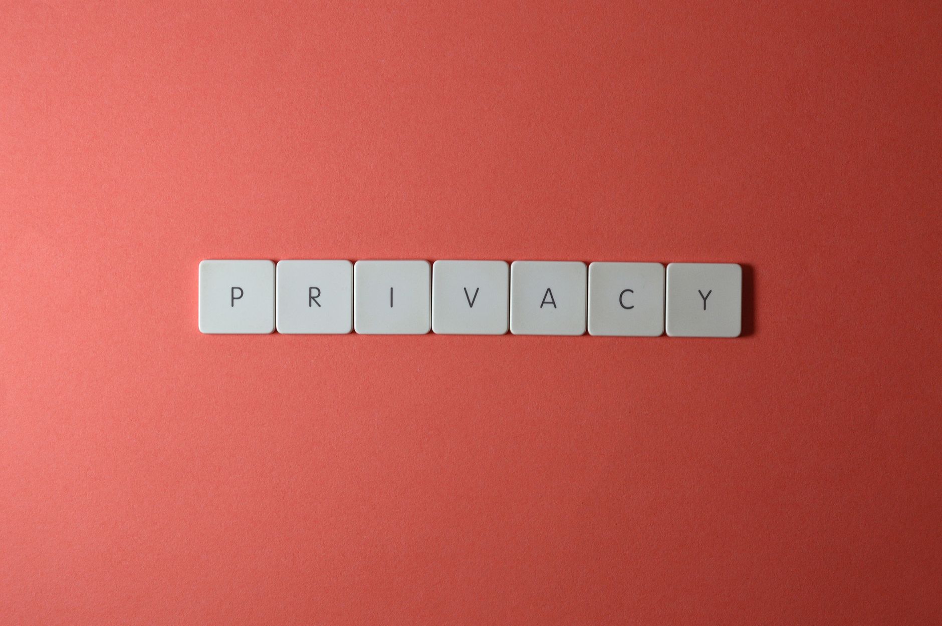 Close-up of letter tiles spelling PRIVACY on a red background, symbolizing data protection.