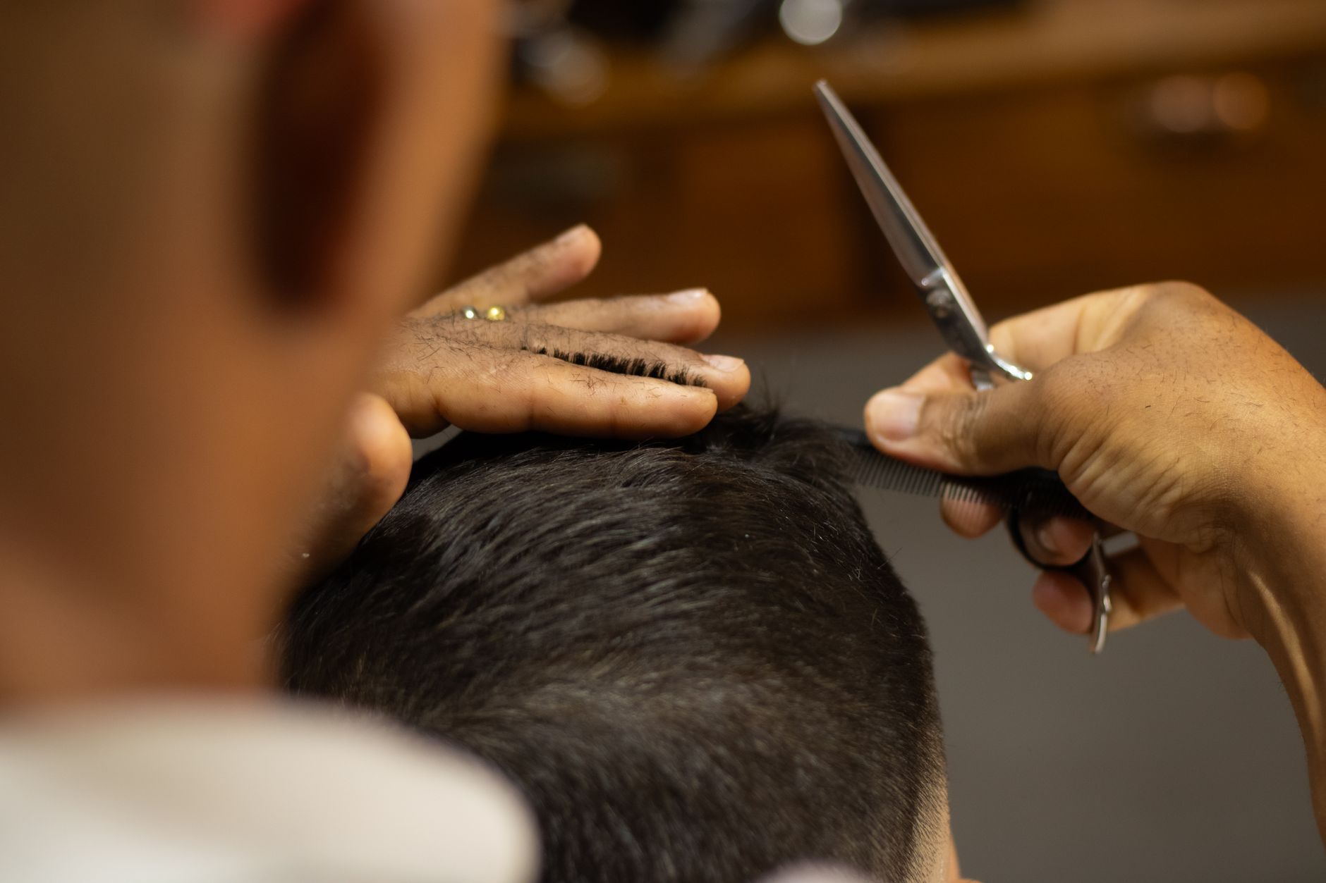 Close-up of a barber expertly cutting a man's hair in a salon. Professional grooming.